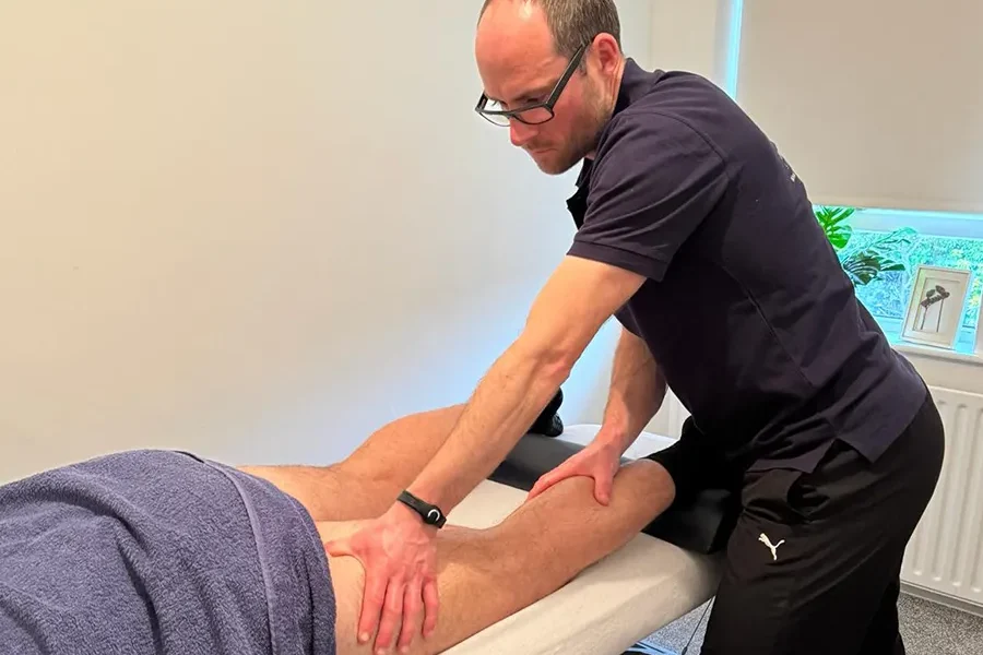 A sports therapist practising sports massage with a patient