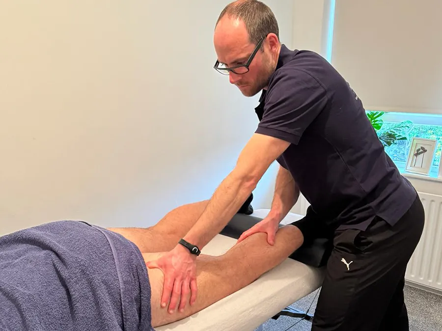 A sports therapist practising sports massage with a patient